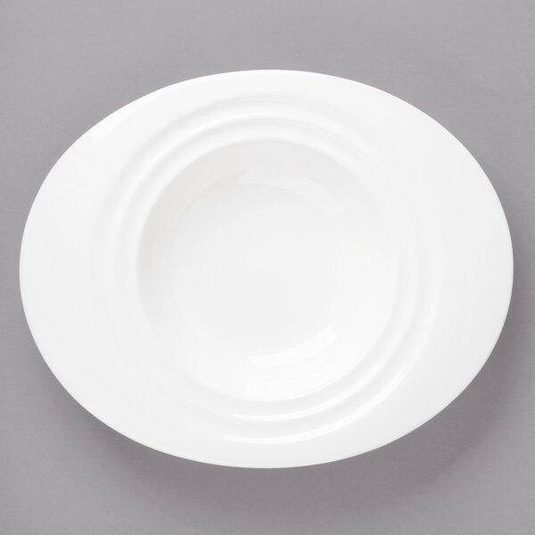 A white porcelain oval pasta bowl on a gray surface.