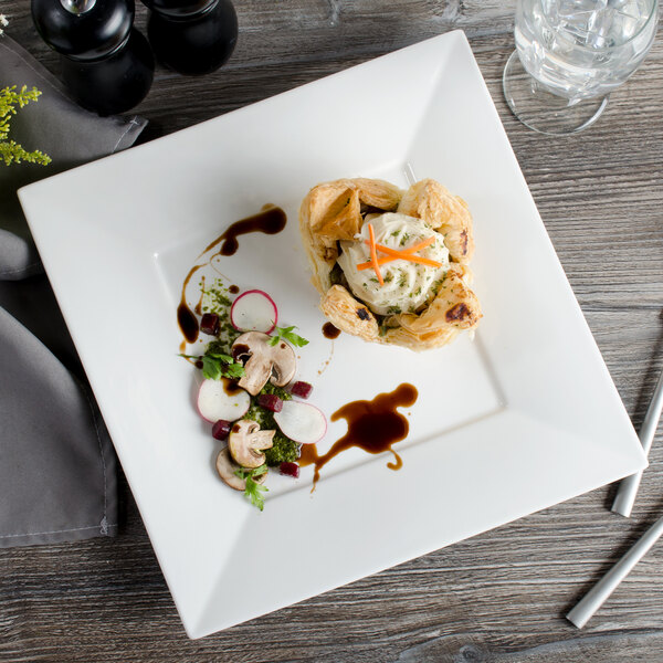A Bon Chef square bone china plate with food on it on a table.