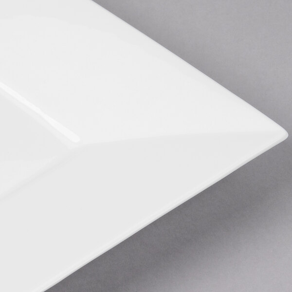 A close-up of a Bon Chef white bone china square plate with a white rim.