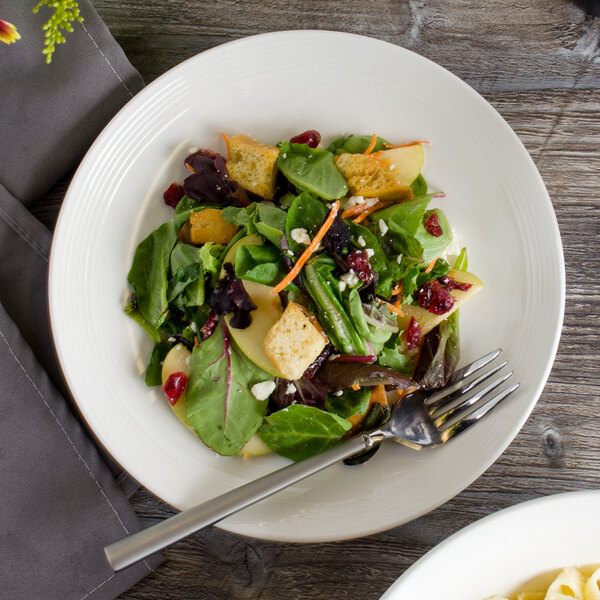A close up of a vegetable salad on a white Bon Chef porcelain plate.