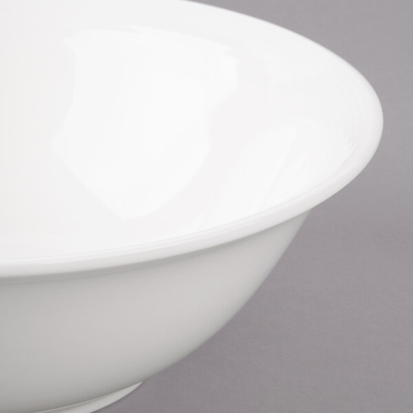 A close-up of a Bon Chef white porcelain bowl with a white rim.