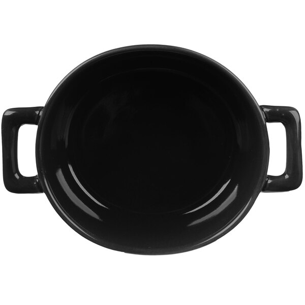A close up of a matte black Bon Chef porcelain oval cocotte with two handles.