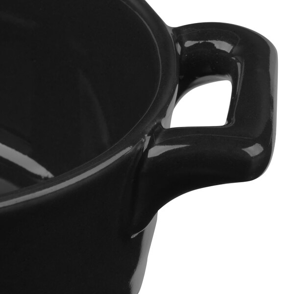 A close up of a matte black Bon Chef porcelain oval casserole with a handle.