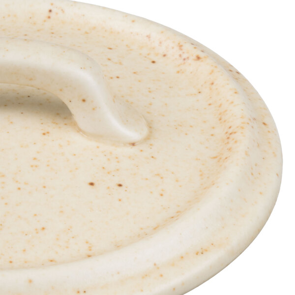 A white ceramic bowl with a handle.