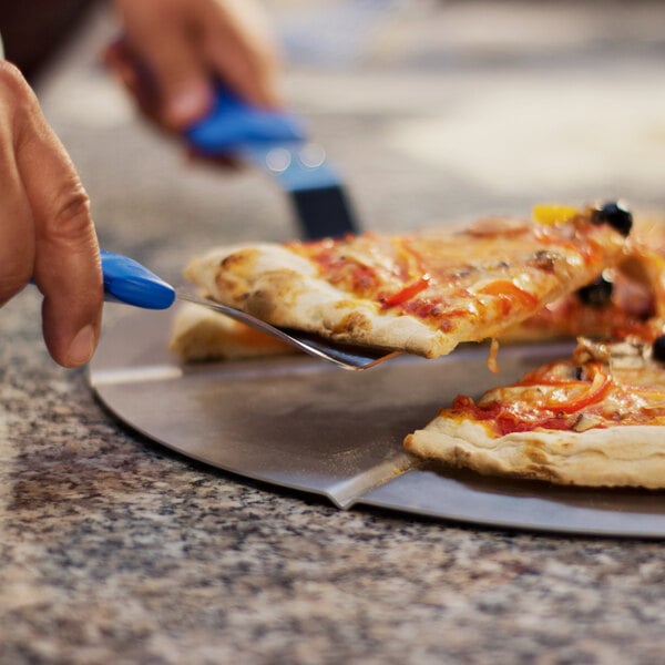 A person using a GI Metal blue triangular pizza server to cut a slice of pizza.