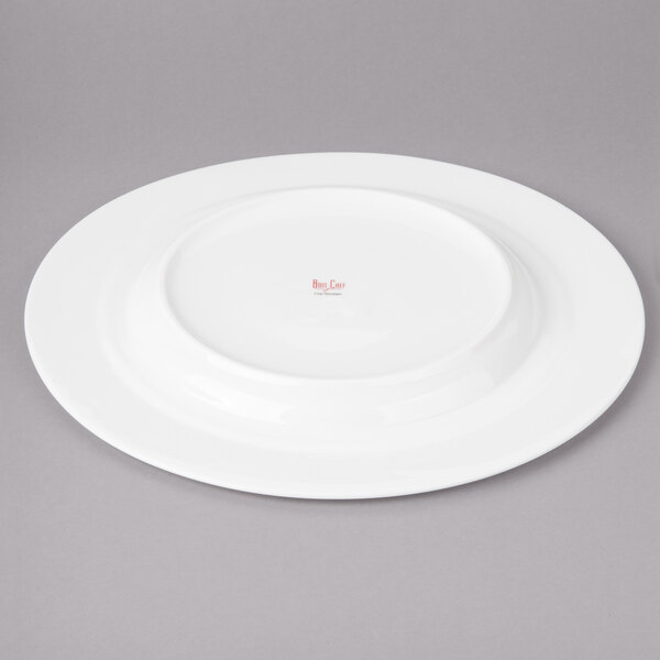 A white porcelain Bon Chef charger plate with a round red rim.