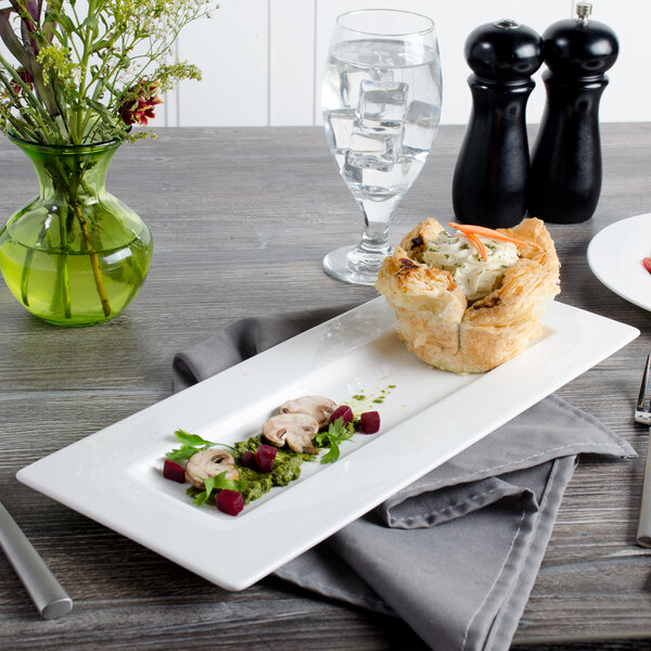 A white Bon Chef rectangular plate with food on it.