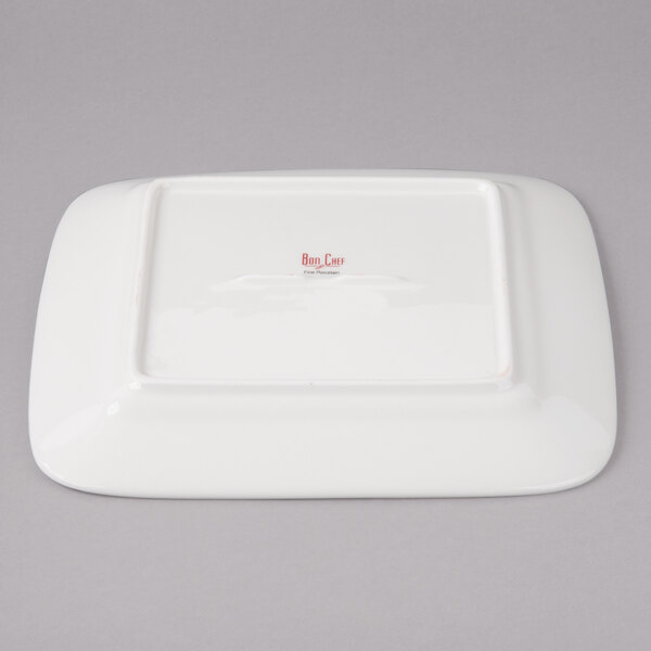 A white square porcelain plate with a red circle pattern.