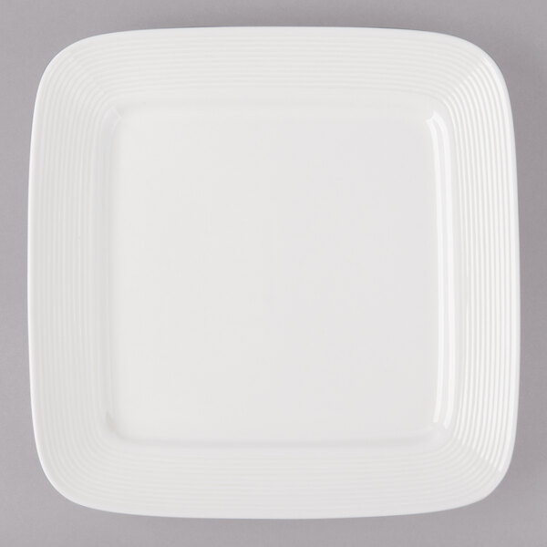A white porcelain square plate with black circle and line accents.