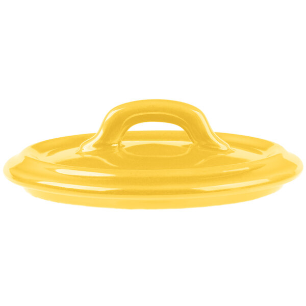 A close-up of a yellow Bon Chef porcelain cocotte lid with a handle.