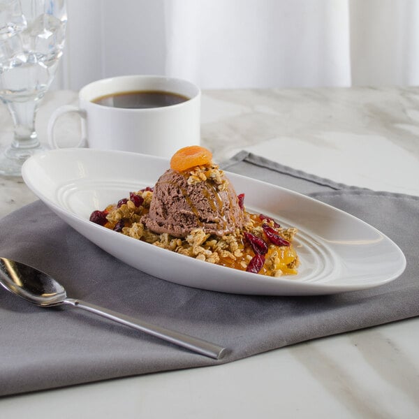 A white porcelain bowl filled with dessert with a cup of coffee on the table.