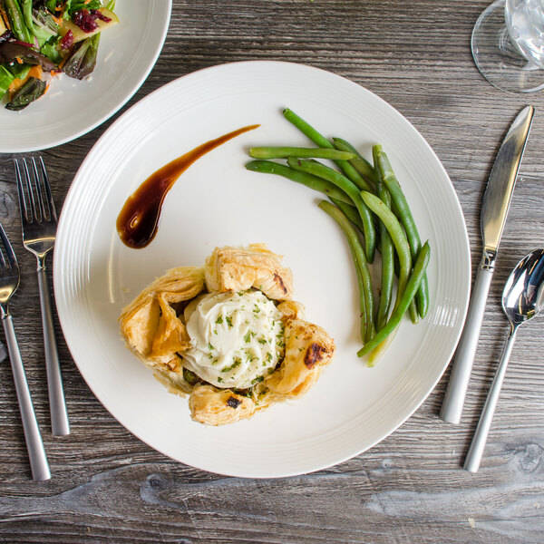 A white Bon Chef porcelain dinner plate with a piece of pie on it.