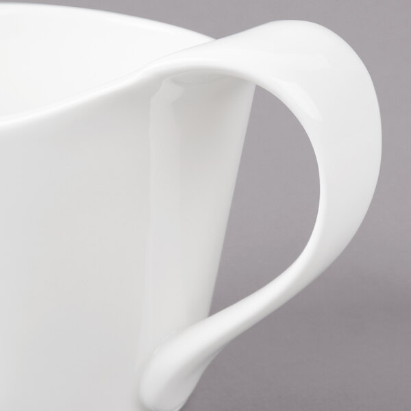 A white Bon Chef bone china cup with a curved handle.