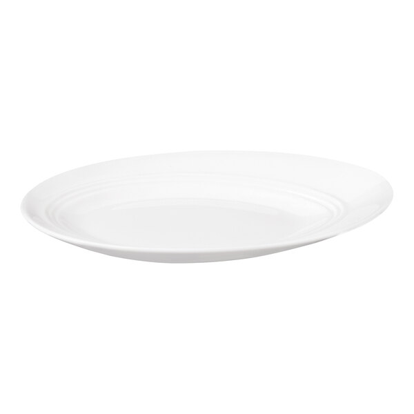 A white, oval-shaped porcelain plate with a slightly slanted design and subtle rim detailing.
