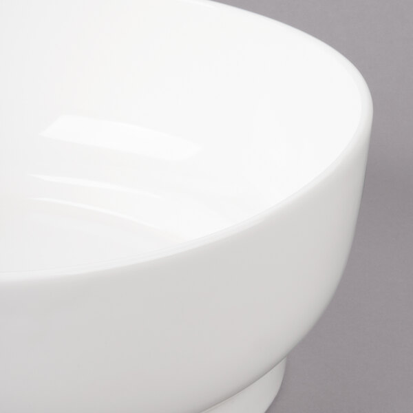 A close-up of a Bon Chef white porcelain bowl with a white rim.
