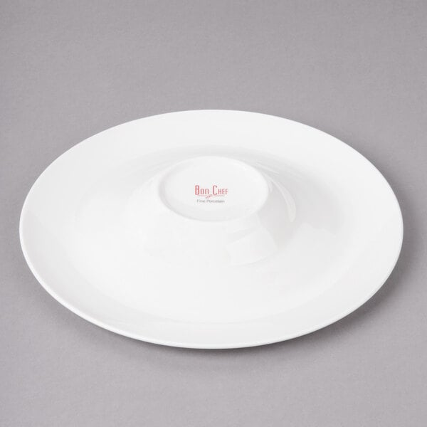 A white Bon Chef porcelain bowl with a red concentric circle design.