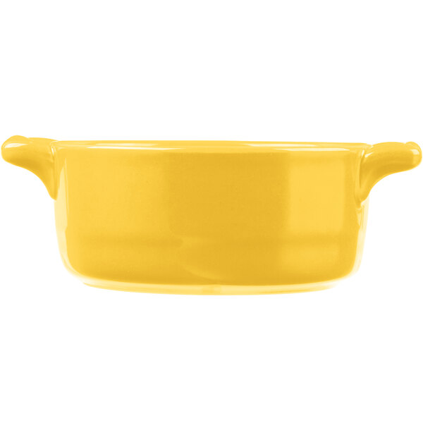 A yellow porcelain oval cocotte with handles.