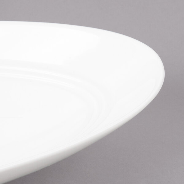 A close-up of a white Bon Chef porcelain bowl with a curved rim.
