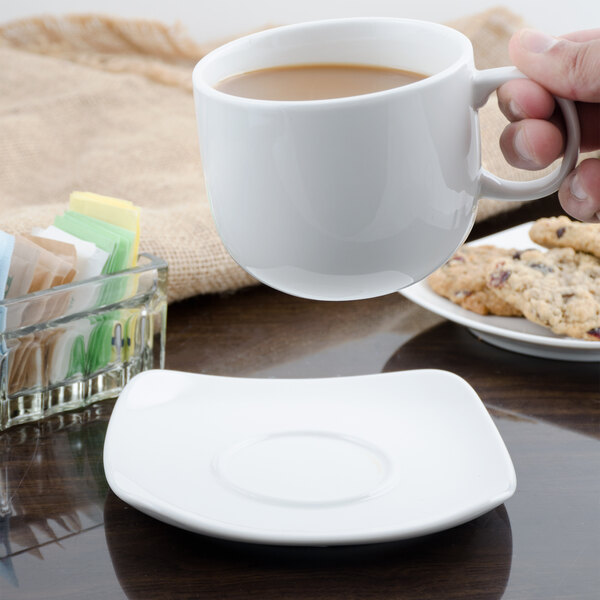 A hand holding a white Bon Chef porcelain saucer with a cup of coffee.