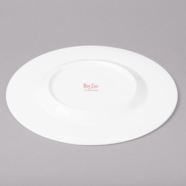 A white Bon Chef bone china dinner plate with a wide rim.