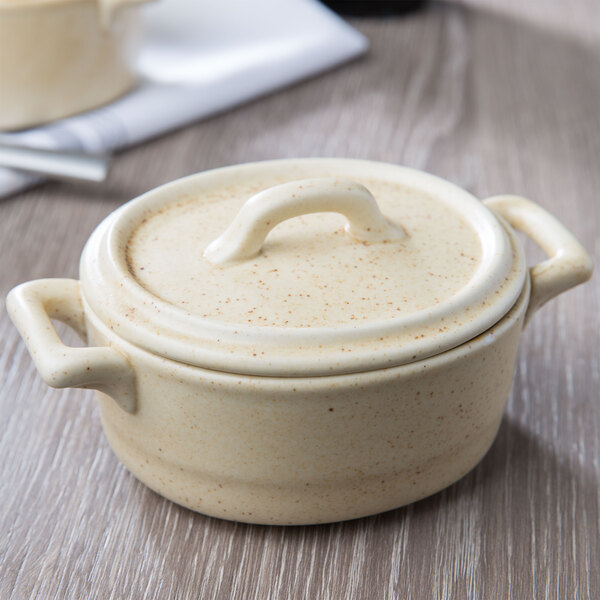 A white porcelain oval cocotte lid with a curved end.