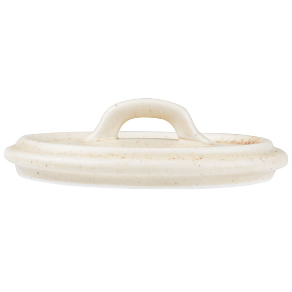 A white porcelain oval lid with a handle.