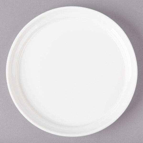 A white Bon Chef porcelain plate with a white rim on a gray surface.