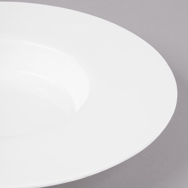 A close-up of a Bon Chef white bone china pasta bowl with a wide rim.