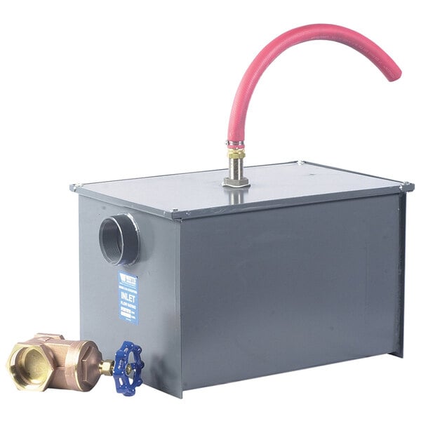 A grey metal Watts grease trap with a valve and hose.