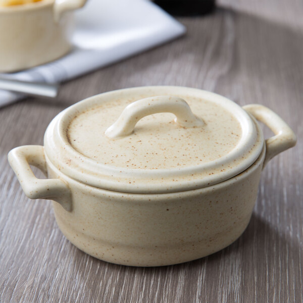 A white porcelain Bon Chef oval cocotte with a lid.