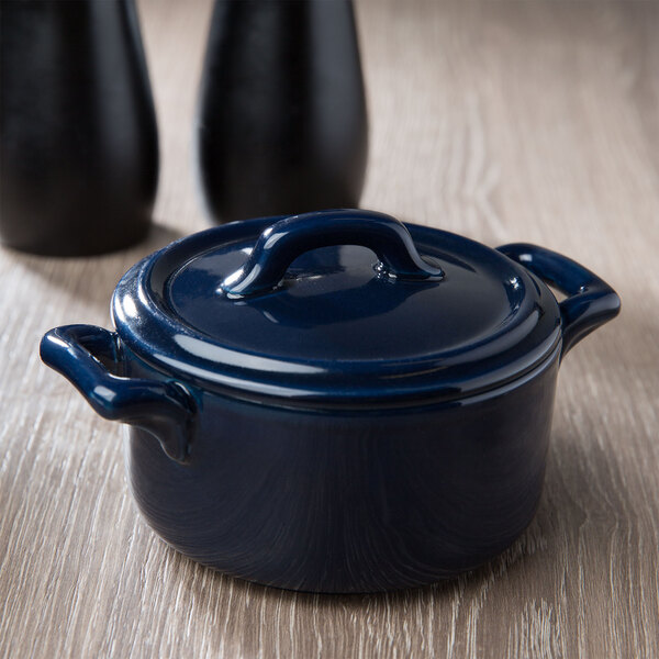 A cobalt blue porcelain cocotte with a lid on a table.