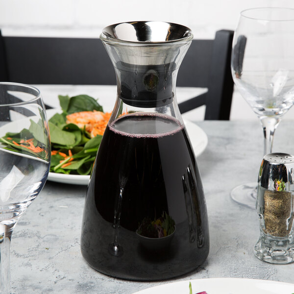 A GET glass decanter filled with red liquid on a table.