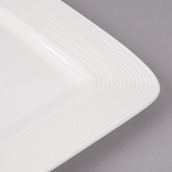 A close-up of a white rectangular porcelain plate with circles on the border.