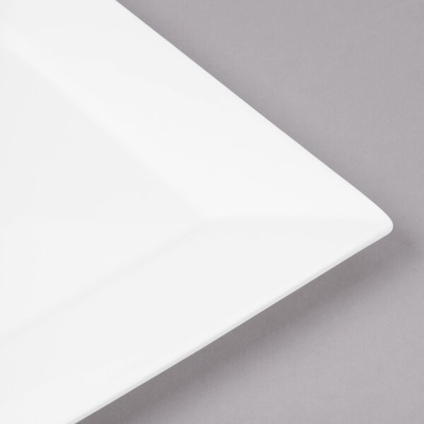 A close up of a Bon Chef white bone china square plate with a wide white rim.