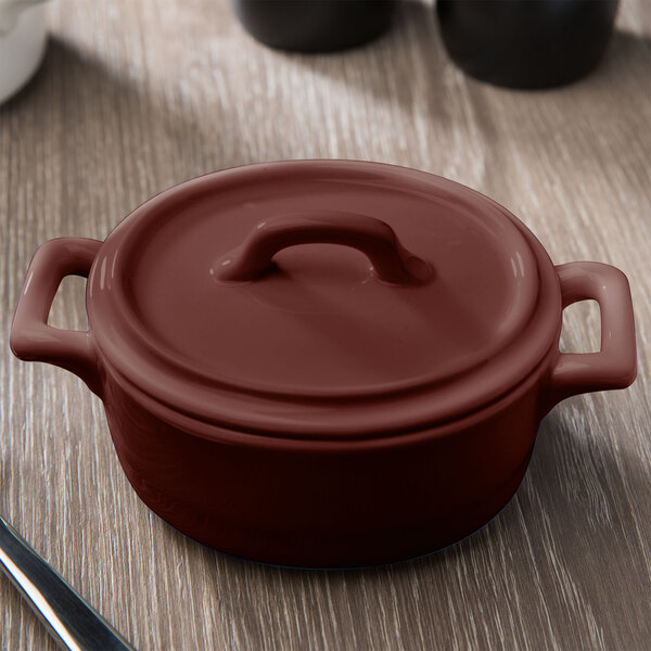 A brown Bon Chef porcelain oval cocotte on a table.