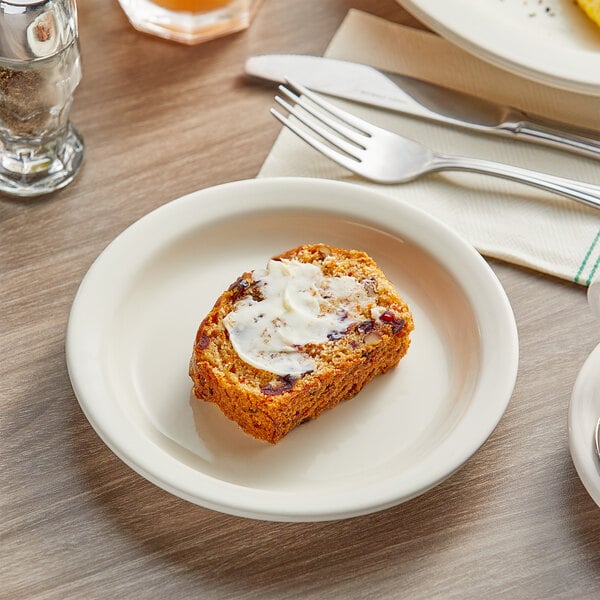 An Acopa narrow rim stoneware plate with a piece of bread and a fork on it.