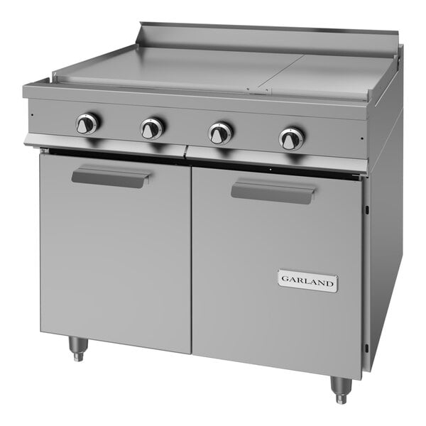 A heavy-duty stainless steel electric range with four control knobs, a flat cooking surface, and a double-door storage base.