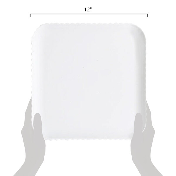 A person holding a white square scalloped polycarbonate plate.