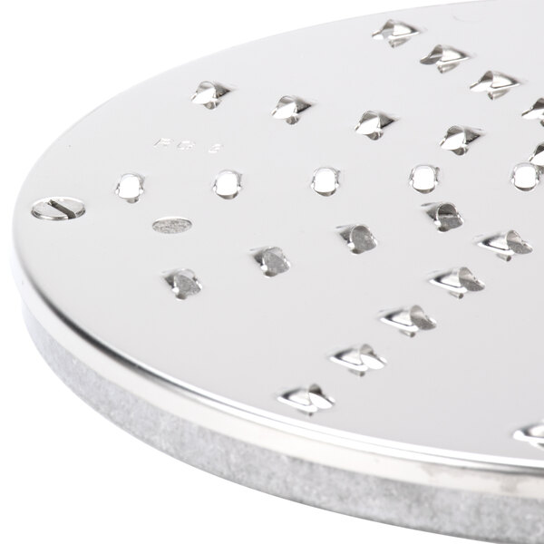 A circular metal disc with holes in it.