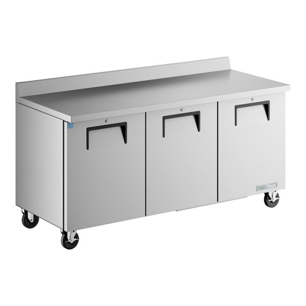 A True worktop refrigerator with a stainless steel countertop and three drawers.