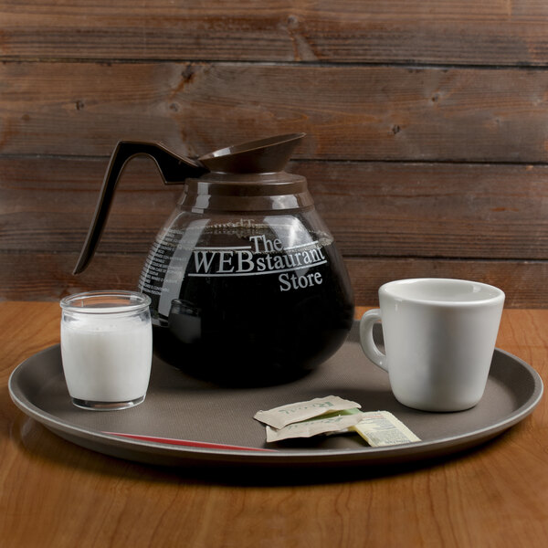 A Cambro Treadlite non-skid tray with a coffee pot, mug, and glass of milk.