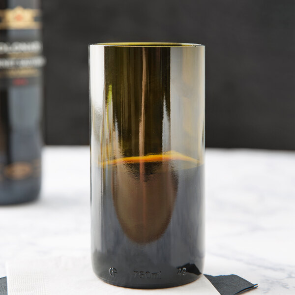 A Libbey dark olive wine bottle tumbler filled with brown liquid.