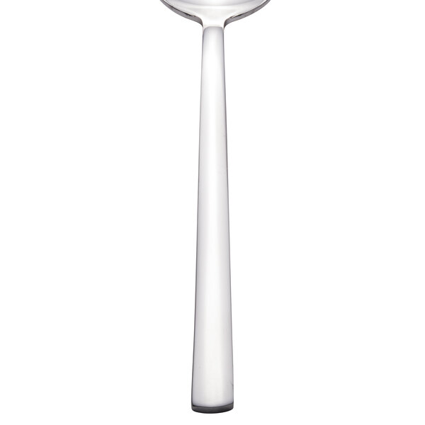 A Walco stainless steel teaspoon with a white handle and silver spoon.