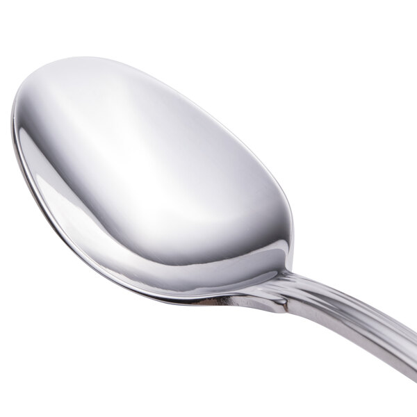 A close up of a Walco Luxor stainless steel demitasse spoon with a silver handle.