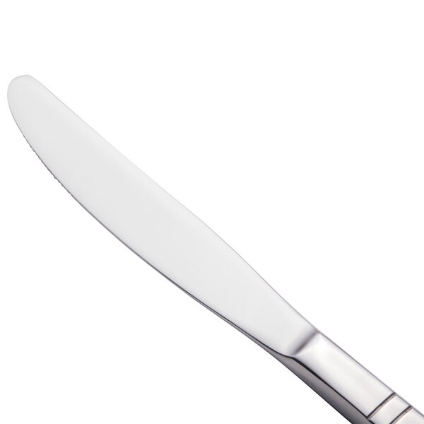 A close-up of a Walco stainless steel table knife with a silver handle and white blade.