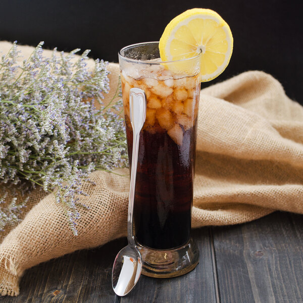 A glass of iced tea with a lemon slice and a Walco stainless steel iced tea spoon.