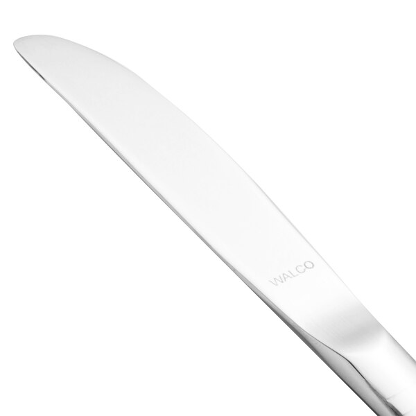 A close-up of a Walco stainless steel butter knife with a solid silver handle.