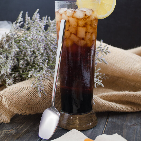 A glass of iced tea with a lemon slice and a Walco stainless steel iced tea spoon.