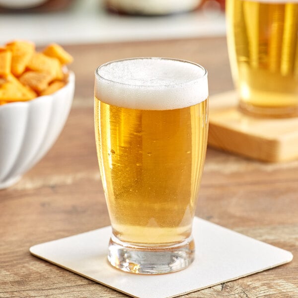 An Acopa Barbary beer tasting glass filled with beer on a table.