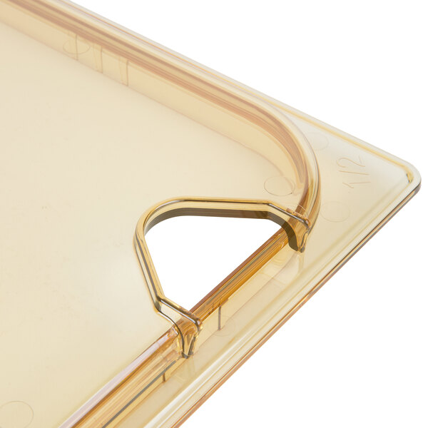 A Carlisle amber plastic lid with a handle.
